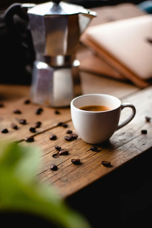 a cup of coffee and some beans on a table