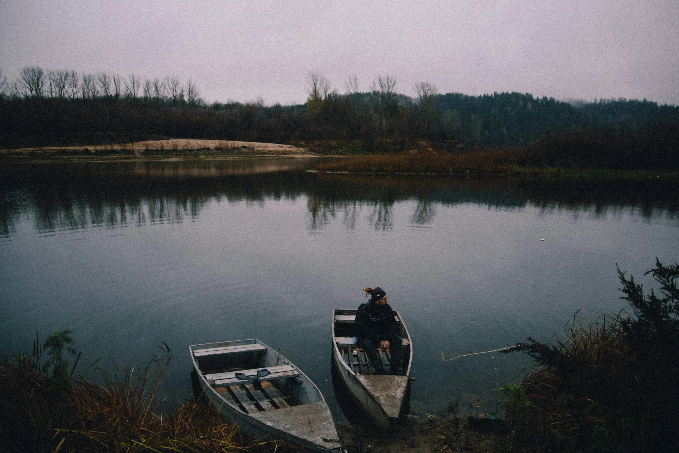 two small boats in a river on a cloudy day