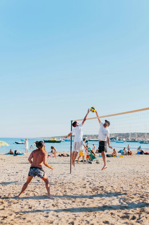 three guys in the sand playing volley ball