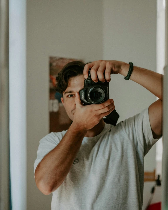 a man holding up a camera taking a picture