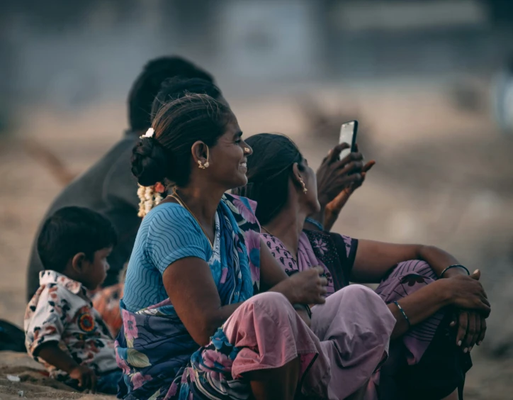 group of women sitting down and looking at cell phones