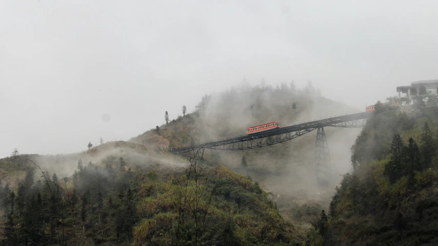 a train engine pulling cars over the foggy slopes