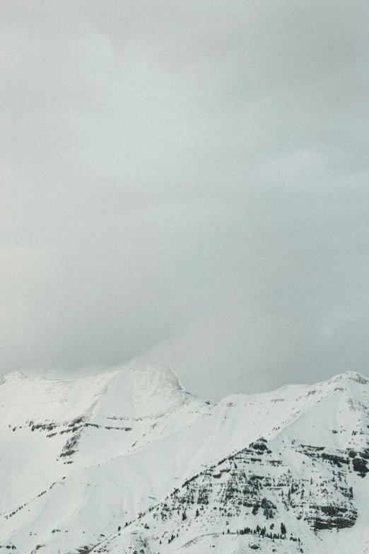 two people standing on top of a snowy mountain