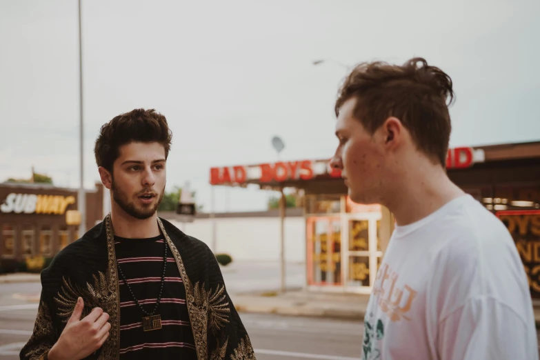 a man wearing black and white looking at another person