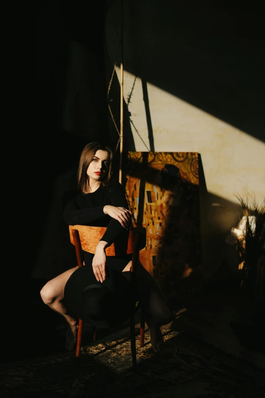 a woman sitting in a chair with a light shining on her