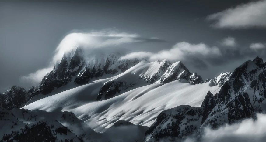 black and white pograph of mountain with snowy mountains in background