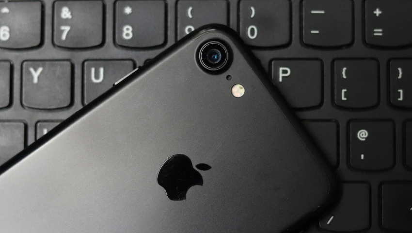 an image of an iphone next to a computer keyboard