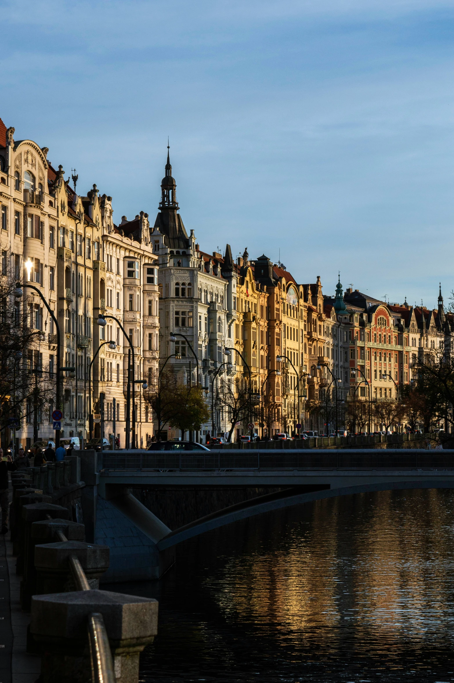 old city buildings line the water as seen from a bridge