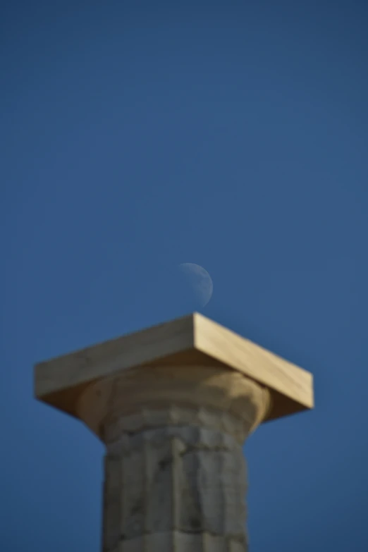 the airplane flies past a large pillar in the sky