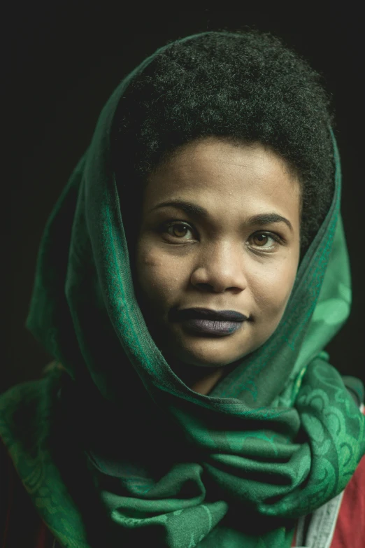 a black woman wearing a green scarf over her head