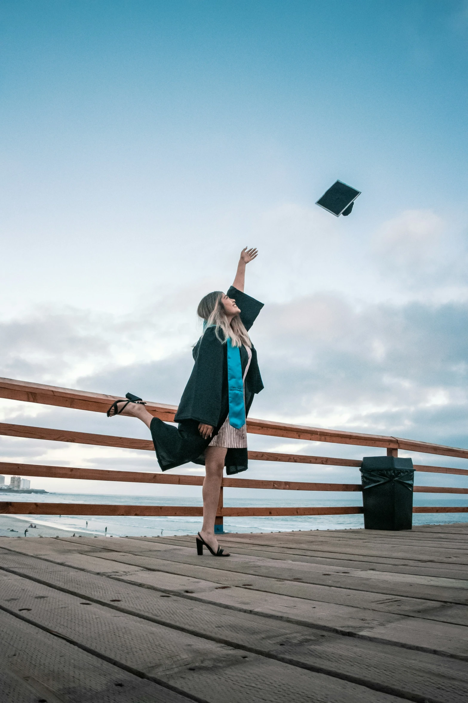 woman in a cap and gown doing graduation flips