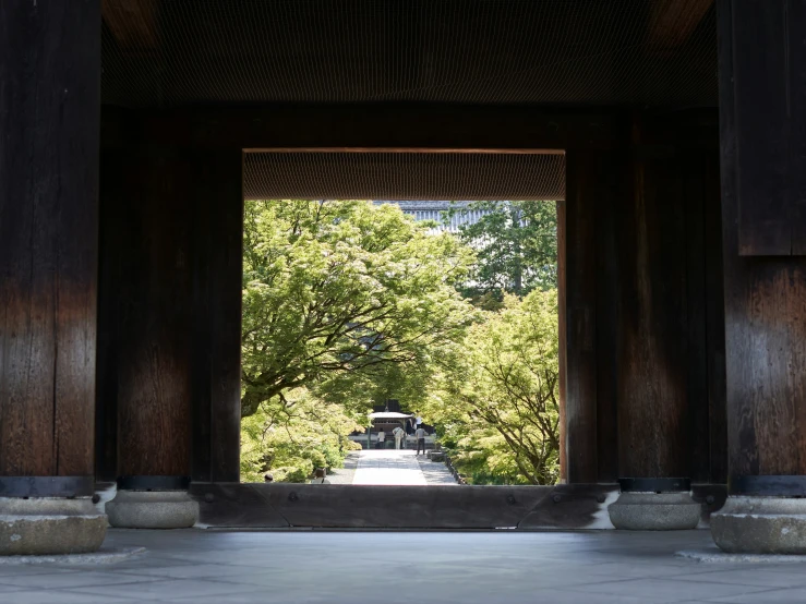 the building has pillars on each side, and trees below