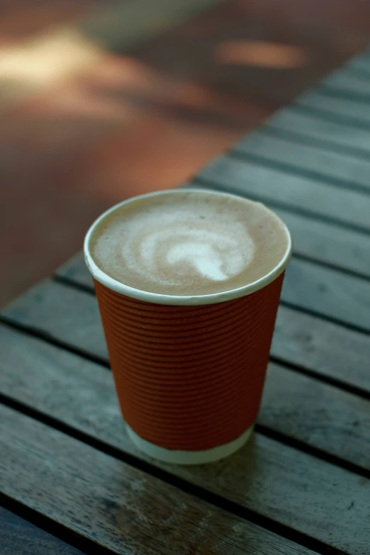 a paper cup that is on a wooden table