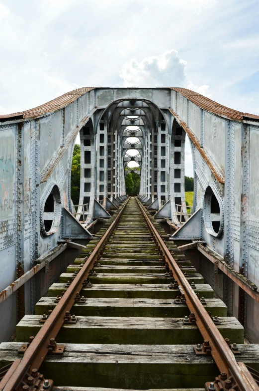 an old and rusty looking train bridge with a few tracks