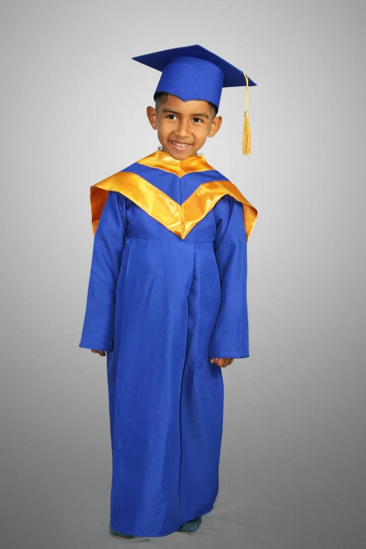 a little boy in a blue and gold graduation gown