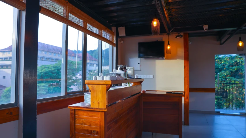 a small bar with an empty counter next to some tall windows