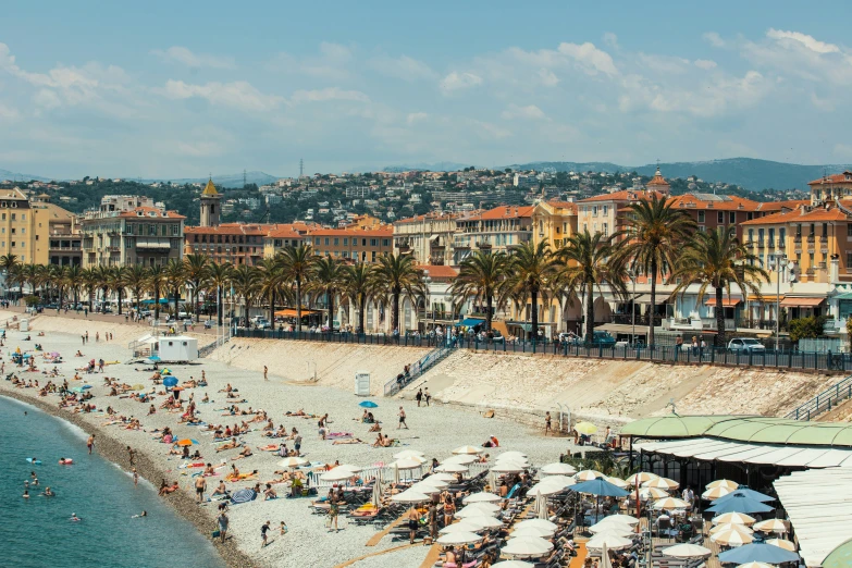 a very crowded beach with many people sitting on the chairs