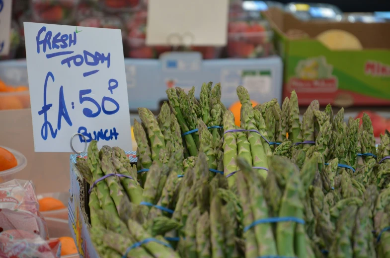 asparagus are piled up next to each other in a produce stand