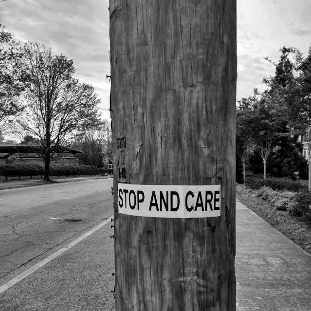 a wooden post has a sign that reads stop and care