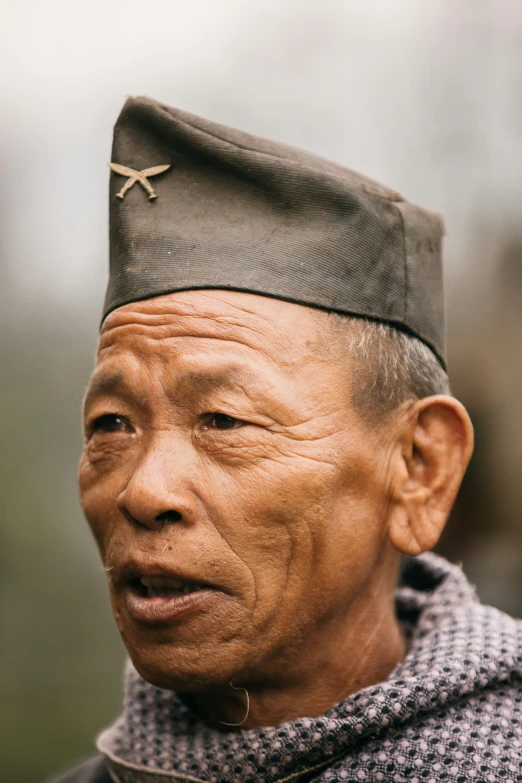 an old chinese man wearing a gray uniform