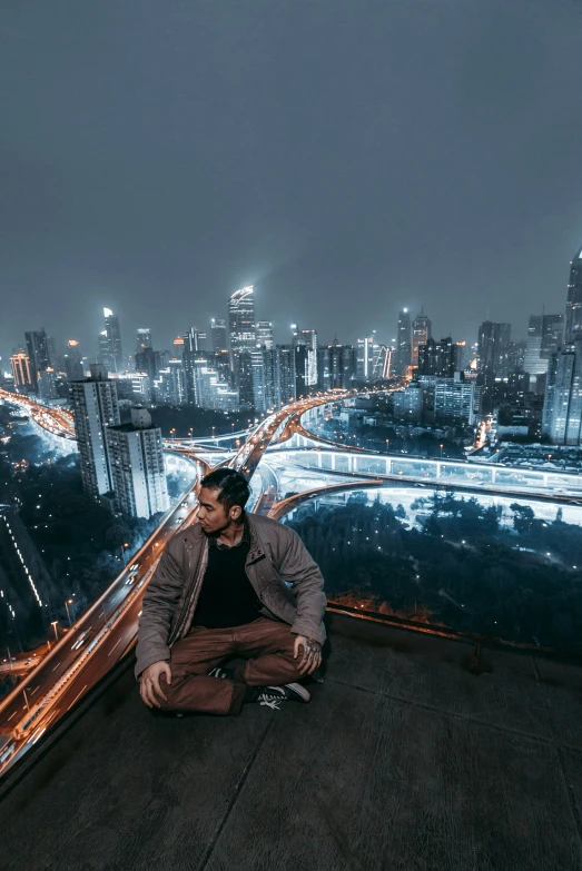 a man sitting on the edge of a tall building