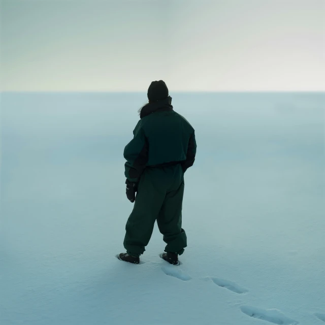 man walking in the snow outside on an overcast day