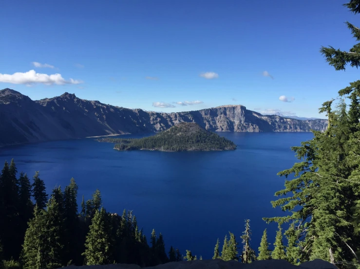 the view over a mountain lake with a lake surrounded by tall pine trees