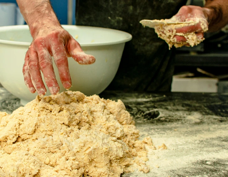 a man mixing a mixture with flour and his hands