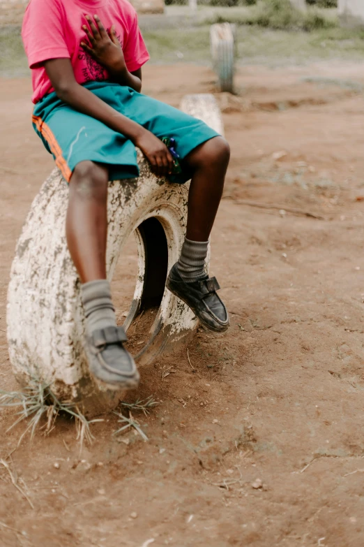 the little girl is sitting on a round chair outside