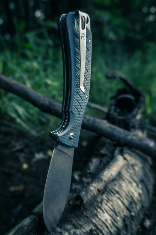 a knife laying next to a piece of wood