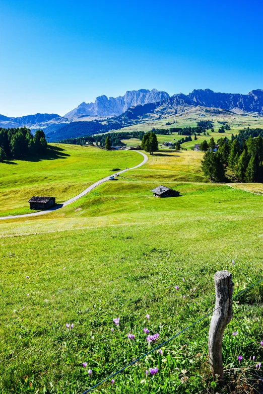 a view of a lush green countryside surrounded by mountains