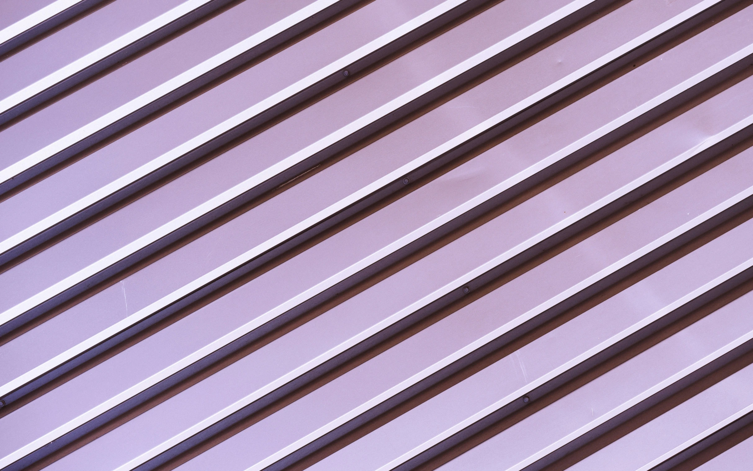 several pins of purple lined up against a blue wall