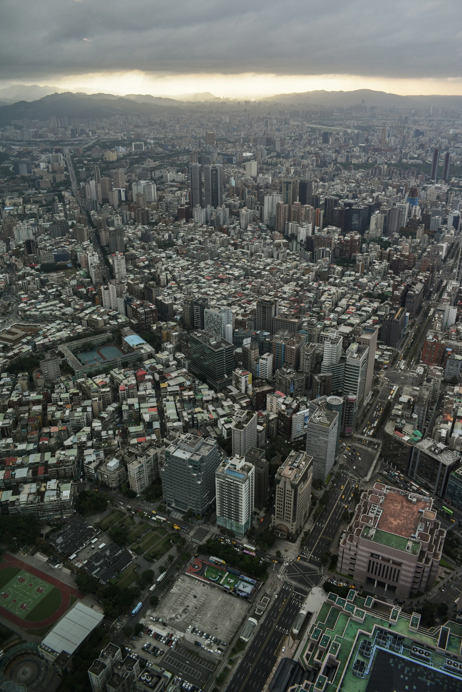 the view of city with lots of buildings, a bus and cars driving