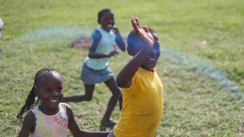 three children are playing in the grass with soing blue