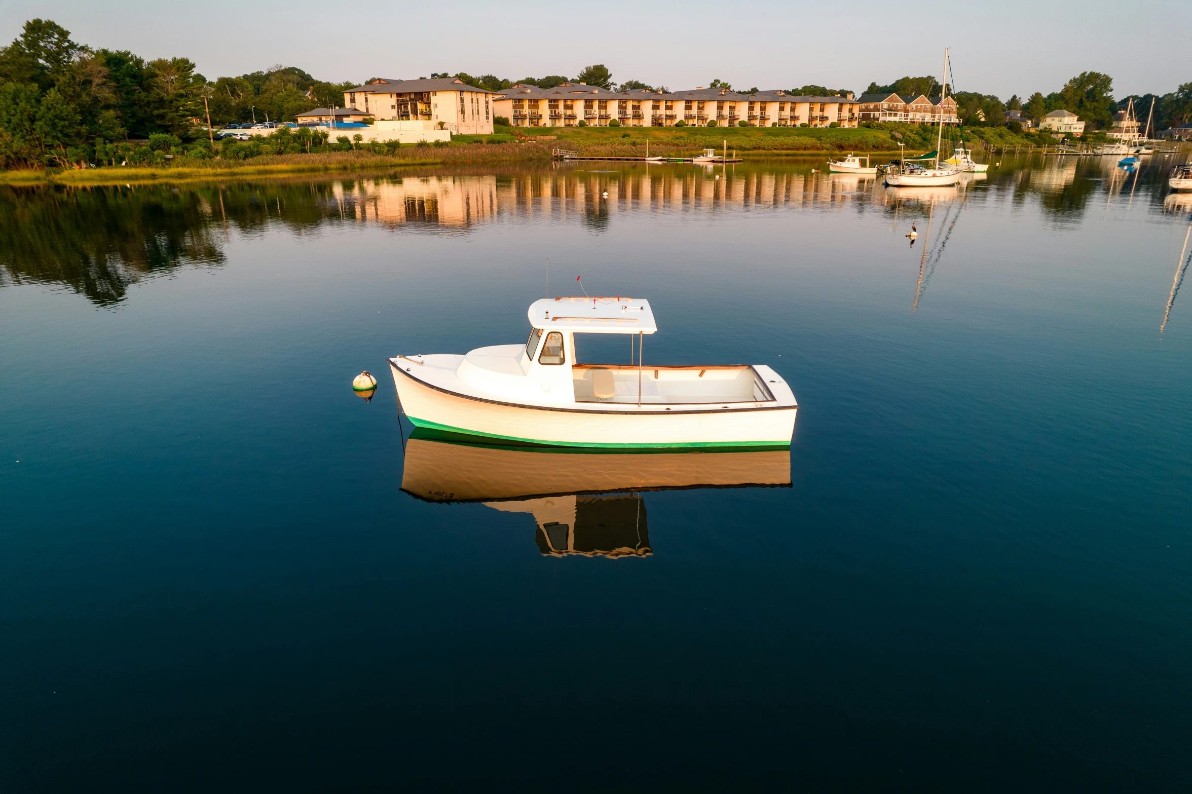 an empty boat floating on water near buildings