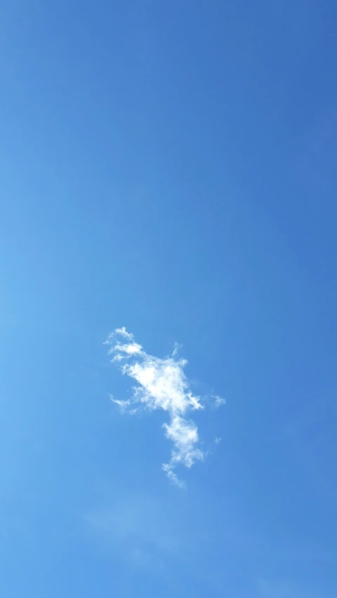 the view of a plane flying above with a cloud in the sky