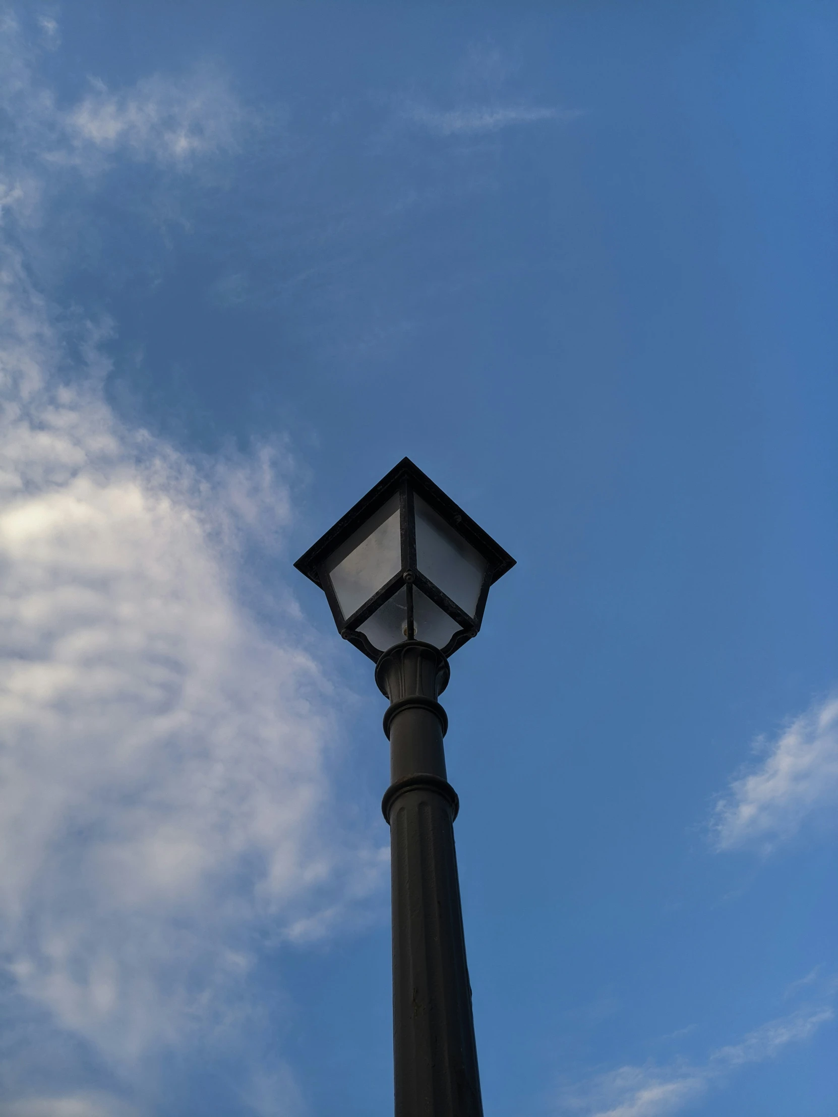 a light post with some clouds in the background