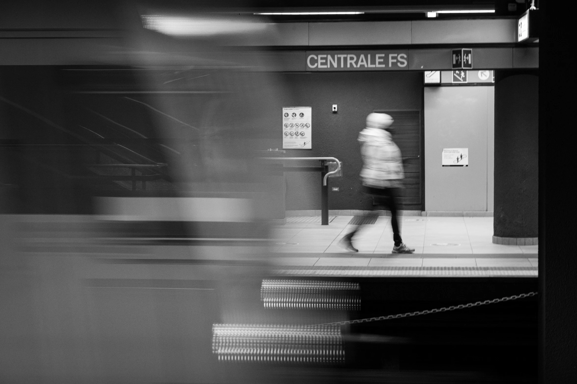 a person walking past a train station as it passes