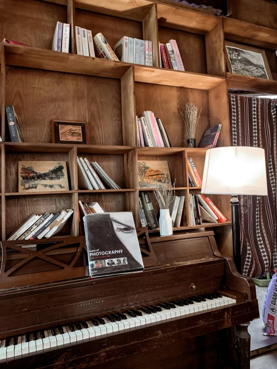 a desk with a lamp and bookshelf in the background