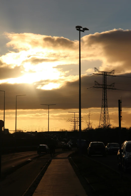 the sun peeking out from behind many power lines