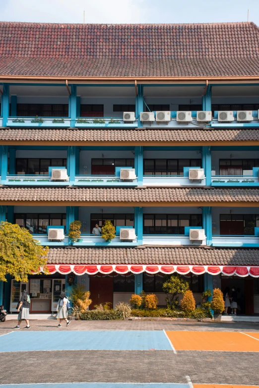 people walking through a courtyard in front of a building