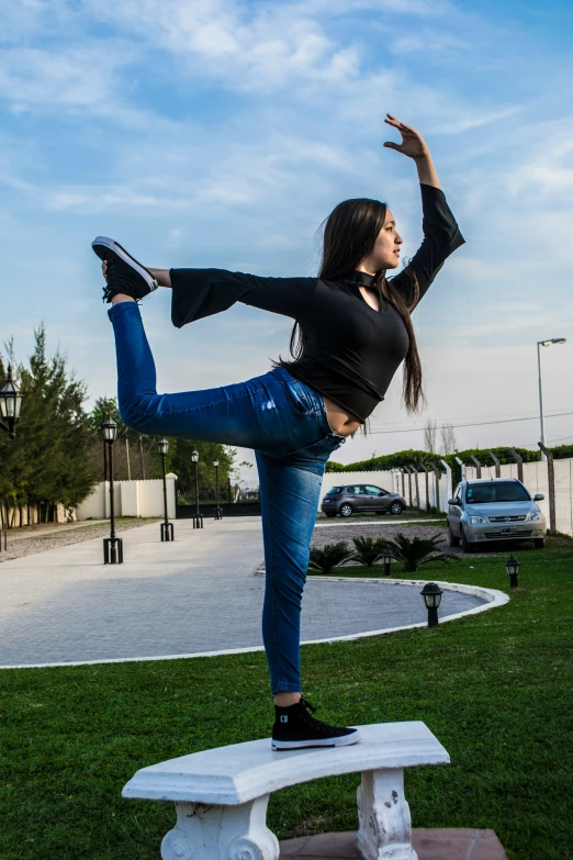 a woman posing for a picture while standing on a bench