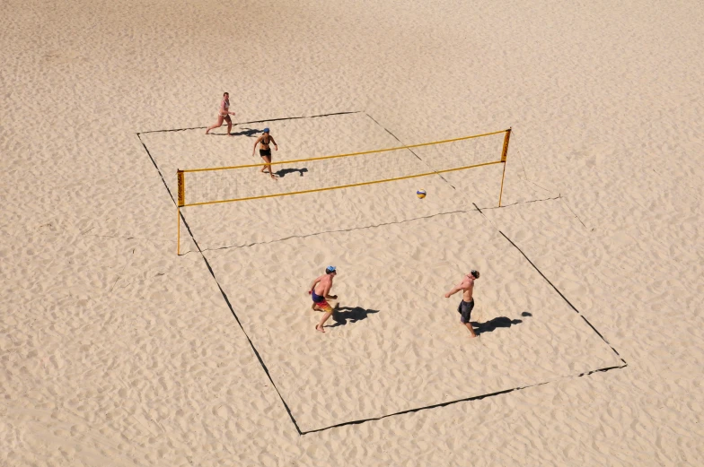 people are playing volleyball on the sand in the desert