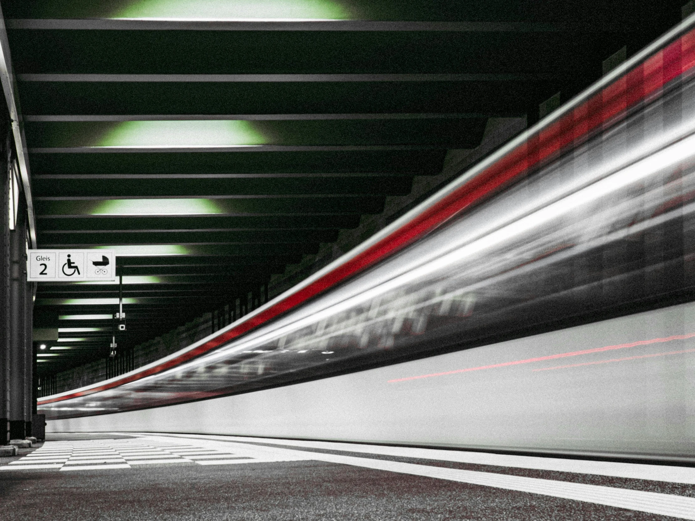 a train passing by a station with long lines on the wall