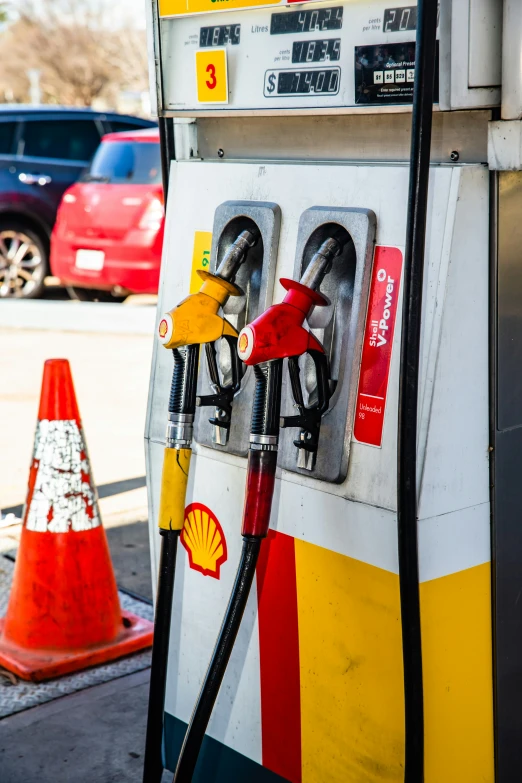 a fuel pump next to traffic cones at a gas station