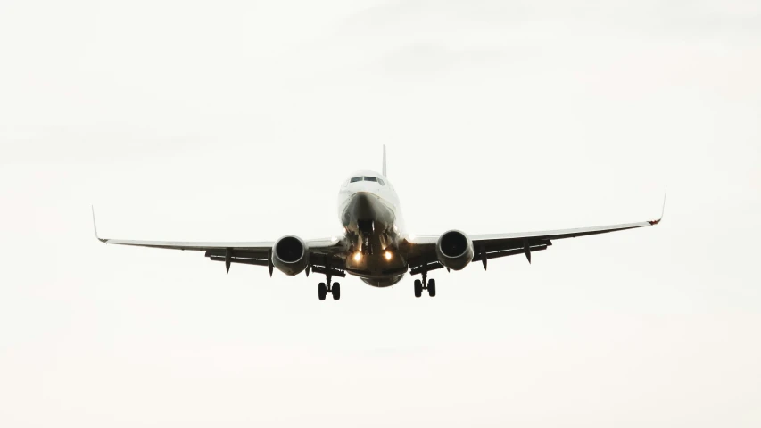 a white and gray jet airliner flying high in the sky