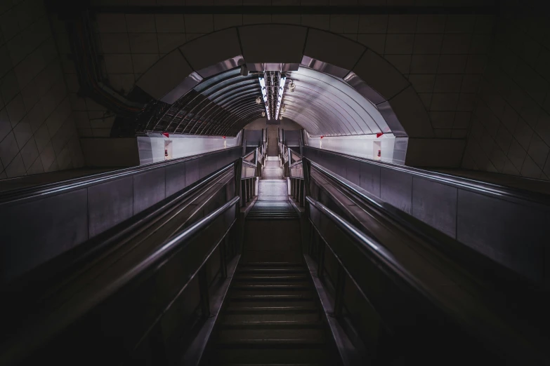 an escalator in a subway station with an empty seat