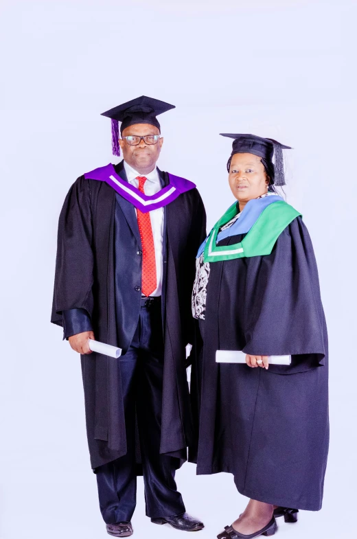 an older man standing next to an older woman in graduation gown