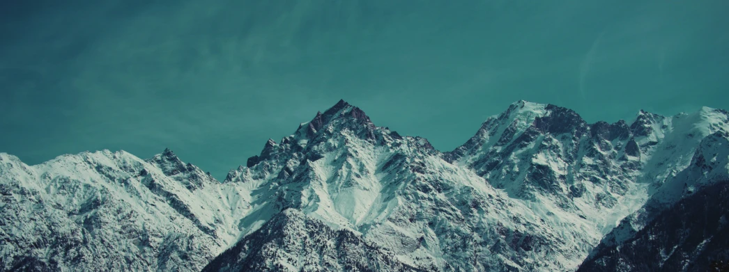 mountain peaks against a blue sky with some clouds