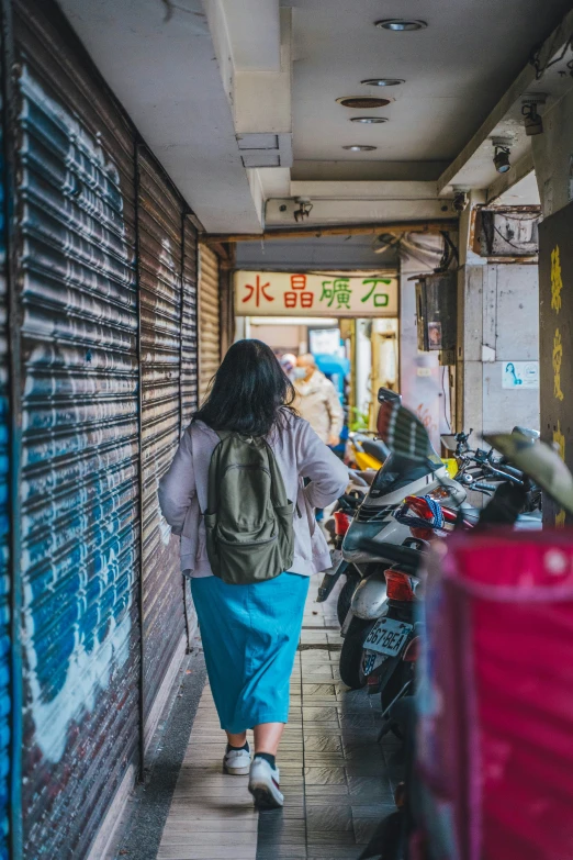 a woman with a backpack is walking down the street